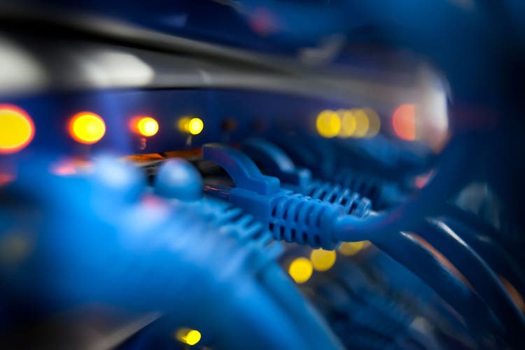 Selective focus closeup view of cables plugged into a server network panel with lights indicating activity. Photographed inside an equipment room. Canon 5D MarkII. The file has been meticulously retouched in Photoshop eliminating dust and unwanted flaws. I have over 22 years experience as a photo retoucher.