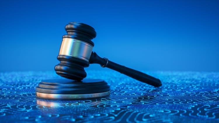 Wooden judge gavel on a blue background with glowing digital circuit patterns, representing the connection between the legal system, data privacy, cryptocurrency regulation, and modernized court processes.