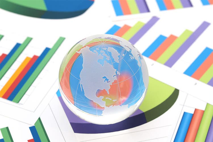 Glass globe of North and South America with graph printed documents